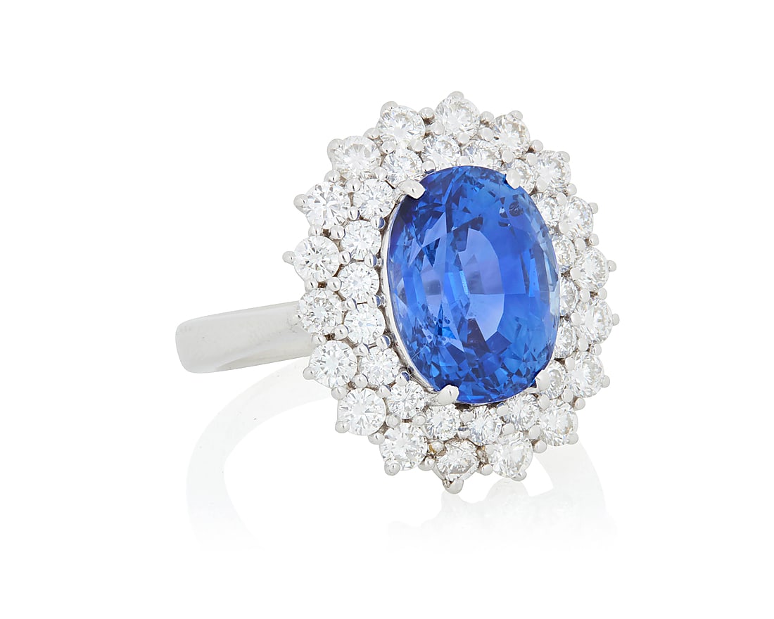 An 18K White Gold, Sapphire and Diamond Ring Centering an oval sapphire weighing approximately: An 18K White Gold, Sapphire and Diamond Ring Centering an oval sapphire weighing approximately 7.40 carats, encircled by two rows of round diamonds weighing approximately 1.55 carats Size: 7 1/4 8.0 g