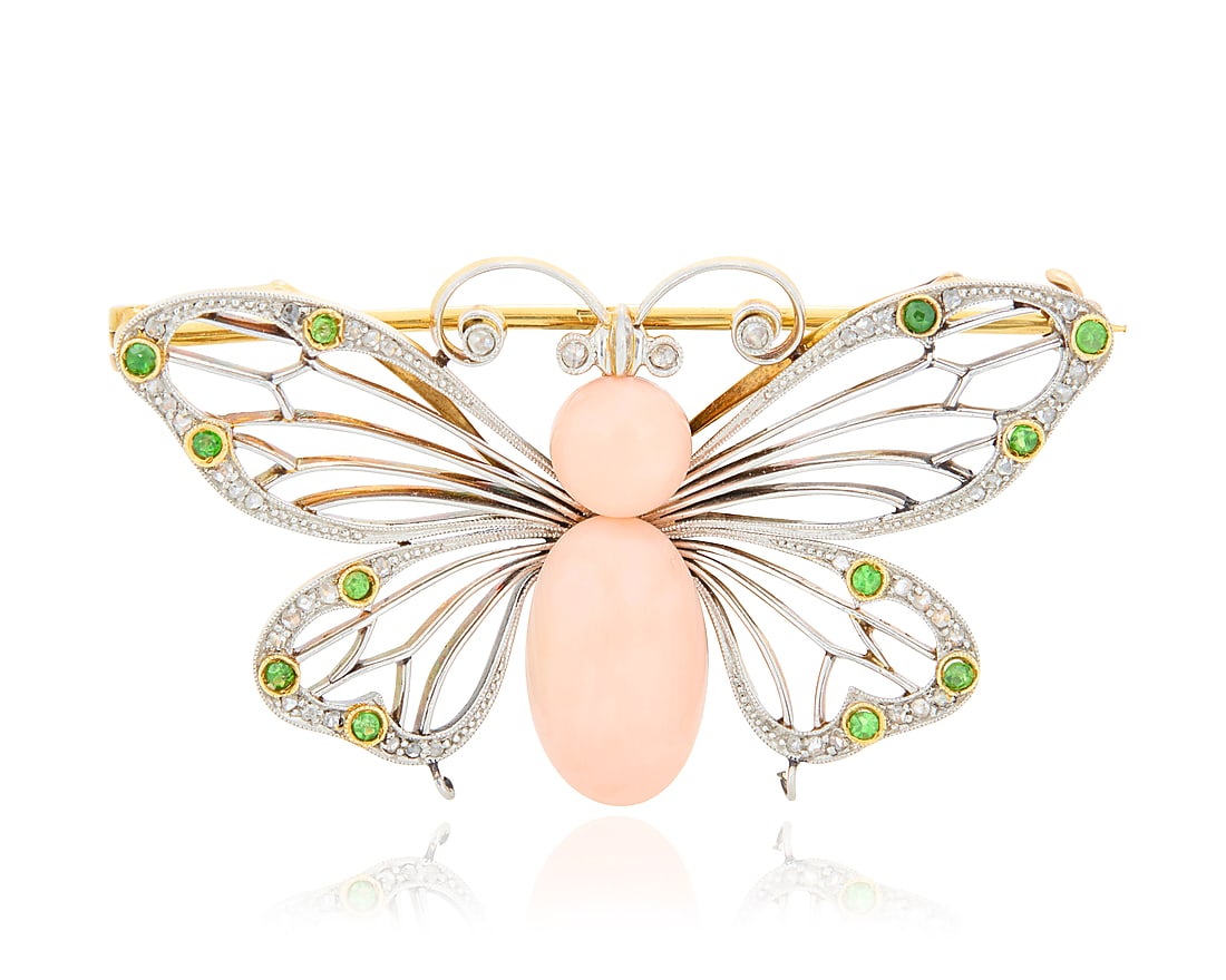 An Antique, Platinum Topped-Gold, Coral and Demantoid Garnet Brooch Of a butterfly design: An Antique, Platinum Topped-Gold, Coral and Demantoid Garnet Brooch Of a butterfly design centering an oval and round coral cabochons, with accents of rose-cut diamonds and round demantoid garnets Mea