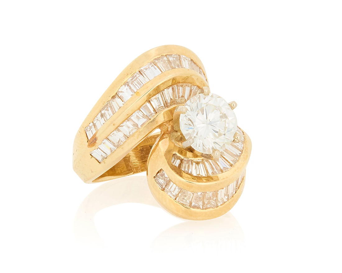 A 14K Gold and Diamond Ring Centering a round diamond weighing approximately round 1.45 carats,: A 14K Gold and Diamond Ring Centering a round diamond weighing approximately round 1.45 carats, mounted in a swirling design set with tapered baguette diamonds weighing approximately 1.90 carats Size: