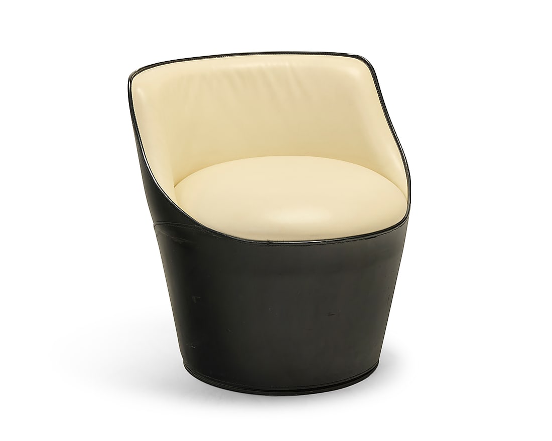 A Fasem 'Shell Big' swivel armchair: A Fasem 'Shell Big' swivel armchair Late 20th century With black leather to exterior and cream leather to seatback and seat, raised on a wood and metal base Unmarked Height 26 1/2 in., width 25 in.,