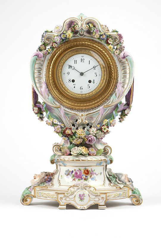A Berlin / KPM porcelain mantel clock: Late 19th / early 20th century, the case with underglaze blue scepter mark with a slash, and incised numbers, the movement stamped with mark of Gustav Becker, further stamped ''1158565'', the circular