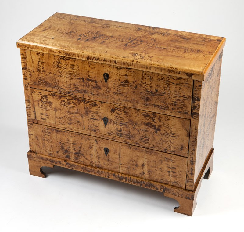 A Biedermeier birch veneer chest of drawers: Mid 19th century, the rectangular top with beveled edge over three drawers raised on bracket feet, 33.5'' H x 39'' W x 17.25'' D, est: $1000/2000