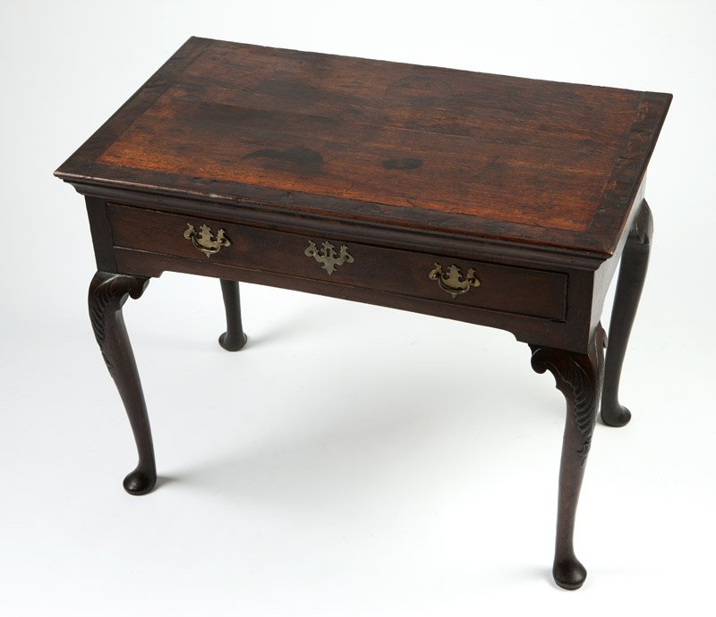 A mid-Georgian oak lowboy: Mid - late 18th century, oak and pine and possibly chestnut secondary wood, the rectangular top inlaid with a border of burl wood, over a single drawer with molded edges, raised on cabriole legs with