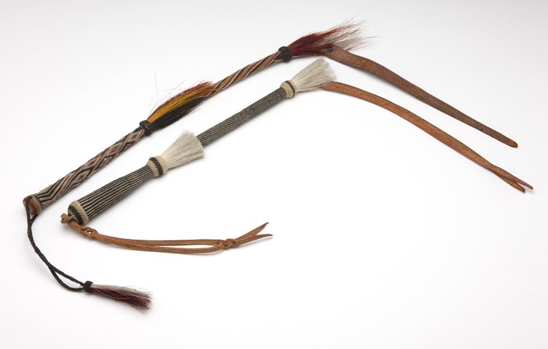 Two Plains Indian braided horsehair quirts: Prison-made style, the first: black and white (27'' long excluding loop to top); the second: multicolored with dyed feathers (29'' long excluding loop to top), 2 pcs, est: $200/300