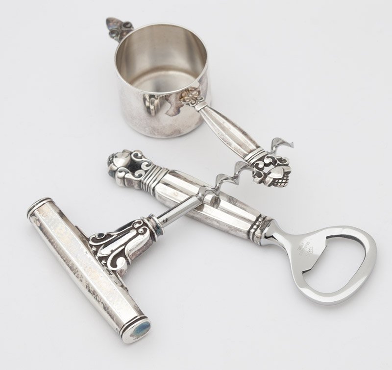 A group of Georg Jensen 'Acorn' sterling silver bar: After 1945, with maker's mark, further marked ''Sterling'' and ''Denmark'', comprising: 1 corkscrew (4''), 1 bottle opener (4.625''), and 1 jigger, with designer's mark of Johan Rohde (4.5''); 3 pcs,