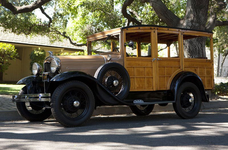 A 1931 Ford Model 'A' woody station wagon: 150 B body style, 40 BHP, 200.5 cu. in., inline four-cylinder engine, three-speed manual transmission, original wire wheels, pin-up windows, the exterior: black fenders, tan body, natural wood; the in