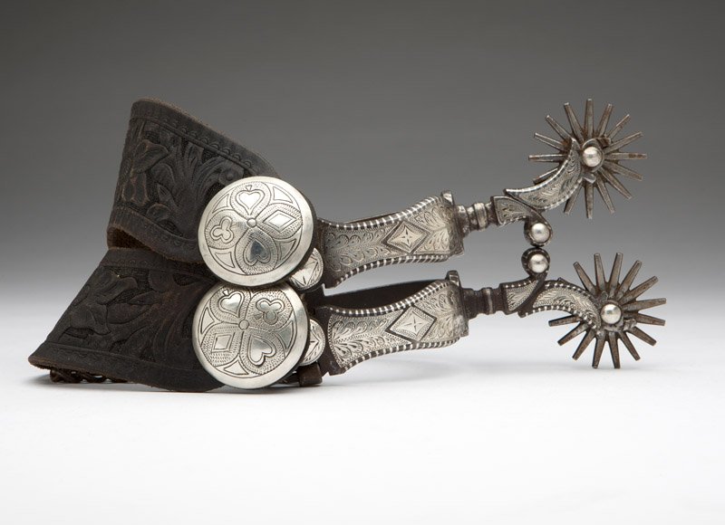 A pair of silver-inlaid California spurs: Last quarter 20th century, silver conchos on spur leathers, est: $250/350