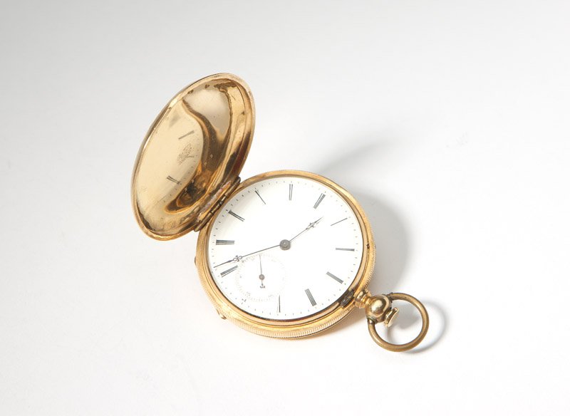 A gent's Henry Beguelin Locle pocket watch: The circular white dial with black Roman numeral hour markers, minute marker sub-seconds, attached to a jeweled un-adjusted movement, key wind & key set, within an 18K yellow gold hunter case, no. 353