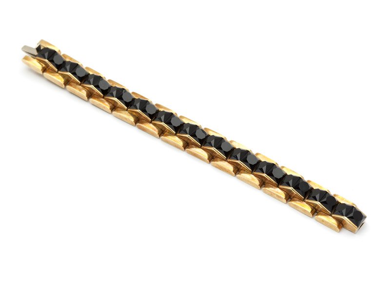 A retro gold and carved black onyx bracelet: The 18K gold links set with faceted black onyx center sectionals, 7'', 73.2 gms gross, est: $2500/3500