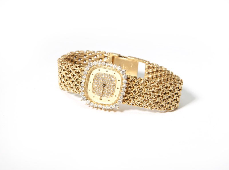 A Patek Philippe diamond and gold wristwatch: The cushion-shaped dial with gold tone dot chapters centering pave diamonds, with gold tone hands, the bezel surrounded by 22 full-cut round diamonds totaling approximately 1.35 cts graded G-H color a