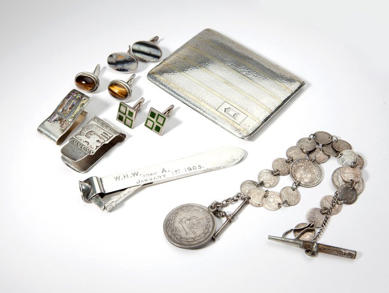 A group of silver gent's articles: Comprising: one silver and gold inlay cigarette case, one cigar cutter, two money clips, one Russian coin watch chain, and three pairs of Georg Jensen cufflinks; one with green enamel #87, one with ov