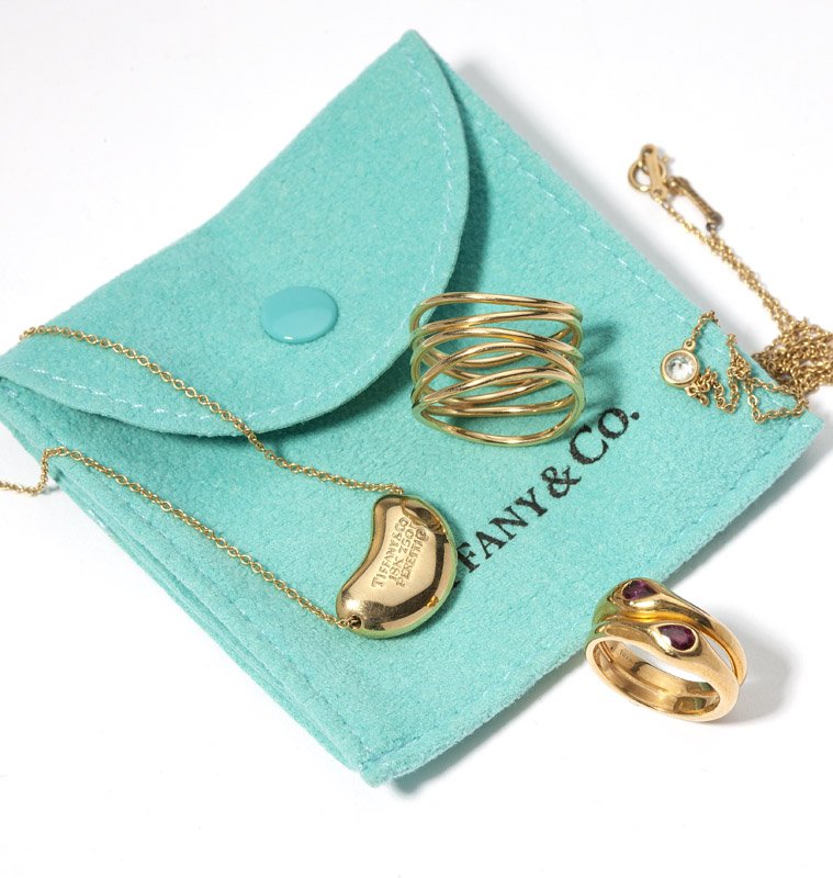 A group of Tiffany & Co. gold jewelry: Including a bean pendant with chain, a diamond bezel with chain, and two rings, sizes 6 and 3, 8.3 gms, est: $800/1200
