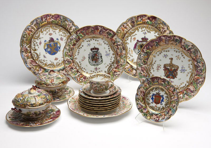A Capodimonte style armorial porcelain part dinner: Early 20th century, with underglaze blue crowned ''N'' mark, possibly for Ginori, comprising: 8 chargers (11.25'' Dia.), 8 dinner / buffet plates (10'' Dia.), 8 luncheon plates (9.25'' Dia.), 8 desser