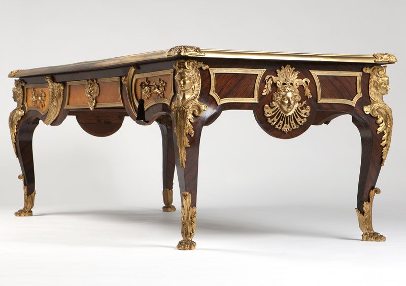 A Regence style gilt bronze-mounted kingwood bureau: Late 19th century, the mounts stamped "Kahn'', designed after the model by Charles Cressent, the rectangular gilt-tooled red leather-inset top within a molded surround with floral and rocaille-cast cl