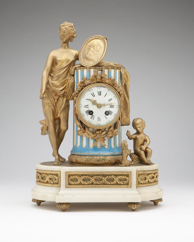 A French gilt bronze, porcelain and marble mantle clock: Late 19th century, in the Louis XVI style, the circular hinged aperture enclosing a white enamel dial with black Roman hours and Arabic five-minute marks and pierced gilt hands, attached to a twin-win