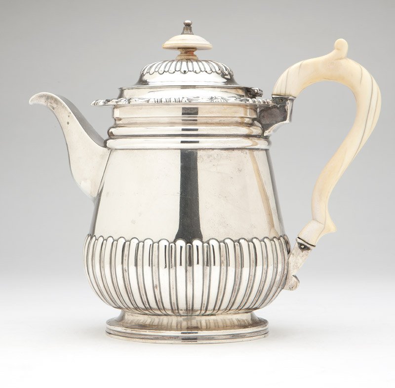 A Regency sterling silver teapot: 1818, Birmingham, maker's mark of Matthew Boulton, the domed, hinged lid gadrooned and topped by a bone finial, the spreading cylindrical body with floral rim and gadrooned to lower half, with a bone 