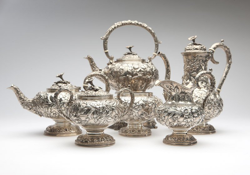 An S. Kirk & Son sterling silver tea / coffee service: Late 19th / early 20th century, with maker's mark, further marked ''925/1000'', comprising: a tipping kettle with burner (13'' H x 9'' W x 7.5'' W), a coffee pot (10.25'' H x 10'' W x 5.5''D), a teapo