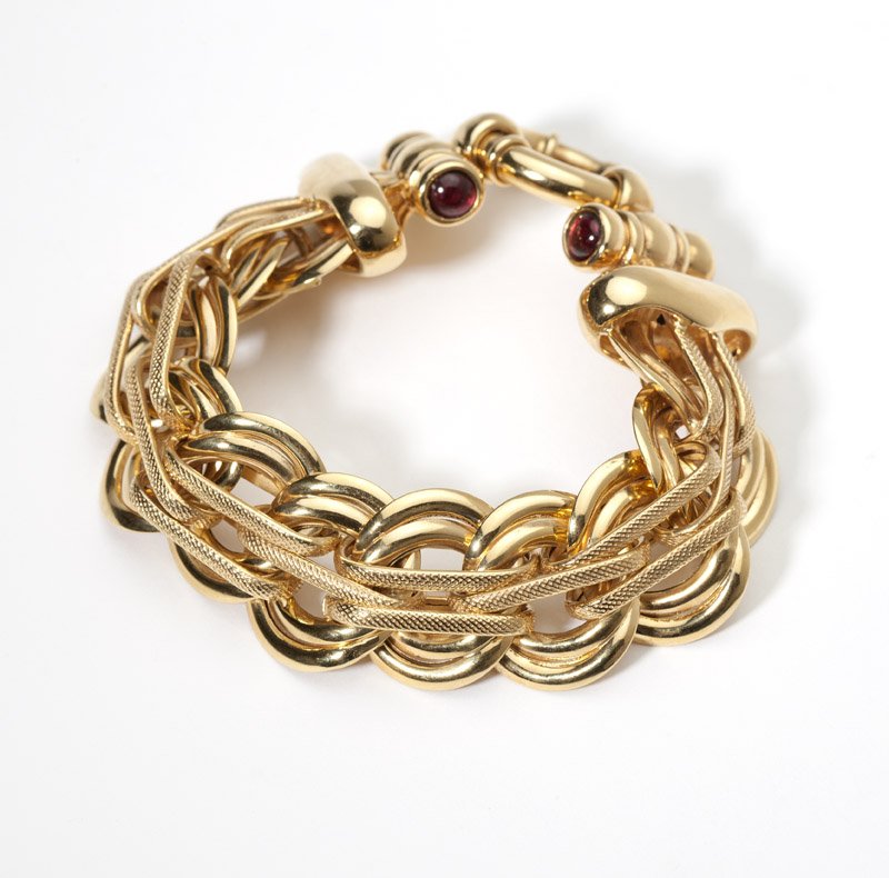A fancy link garnet and gold bracelet: 18K gold, of fancy circular and bar links, terminating with clasp set with four cabochon garnets, 1'' x 8'', 37.6 gms gross, est: $600/800