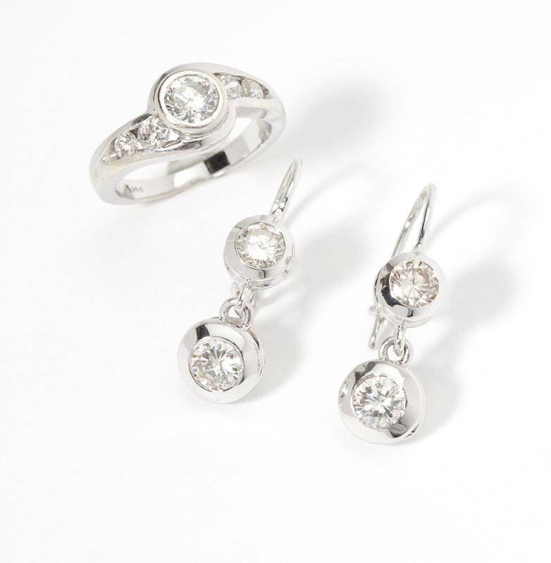 An assembled set of diamond jewelry: 14K white gold including a ring, size 4.75 and a pair of earrings, 3/4", total set with nine full-cut round diamonds weighing approximately 1.50 cts, and graded H-J color and SI-I clarity, est: $800/1