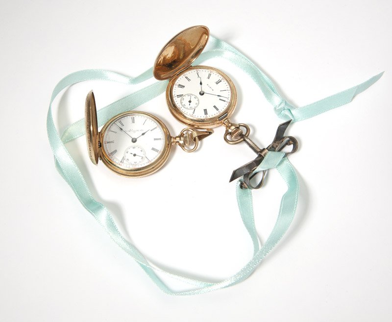 A group of two Elgin hunter case pocket watches: The first; a round white dial with Roman numeral hour markers, sub-seconds, dial signed ''Elgin'', attached to a 7 jewel movement, serial: 12648790, within a 14K Keystone gold hunters case with etched