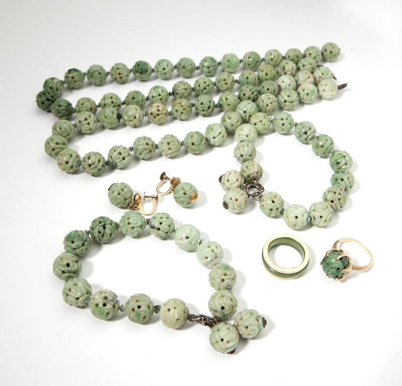 A group of carved jadeite jewelry: Including two necklaces and two bracelets of carved and pierced jadeite beads measure 13mm, with silver clasps; a 14K gold ring; a pair of screw back gold-fill earrings and a gold-toned band, 7 pcs, e