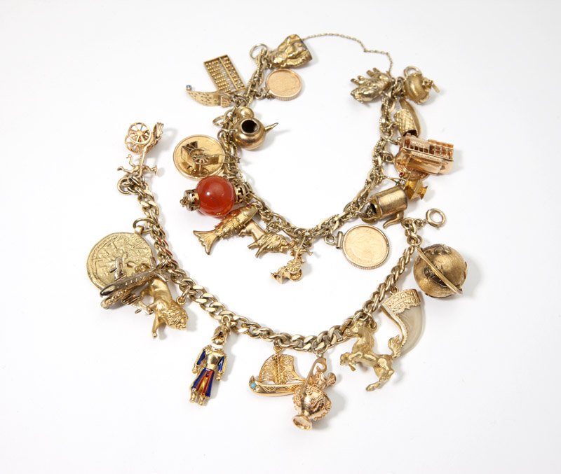 Two gold charm bracelets: 14K gold chain bracelets, both with mixed karat gold, a few gold-filled, the first with 10 charms, including a globe and an airplane that lifts up to reveal interior seats; the second with 19 charms,