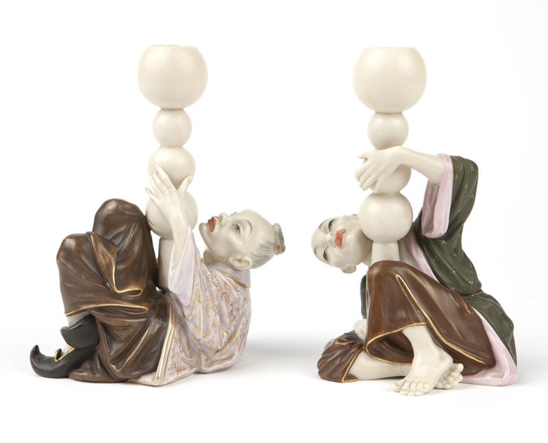 A pair of Royal Worcester porcelain candlesticks: 1881, each with printed factory mark and date code 'S'', impressed factory mark and further impressed ''796'' and ''S4'', each modeled as a seated Mandarin juggling spheres, polychrome-painted with gi