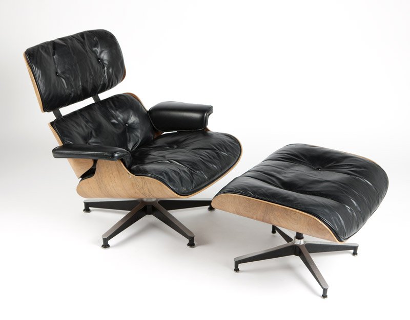 Charles Eames (1907 - 1978) & Ray Eames (1912 - 1988): A '670' lounge chair and '671' footstool, introduced 1956, these examples 1970s, chair retains paper Herman Miller upholstery tag, each shell of rosewood-veneered plywood, with black leather cushions,