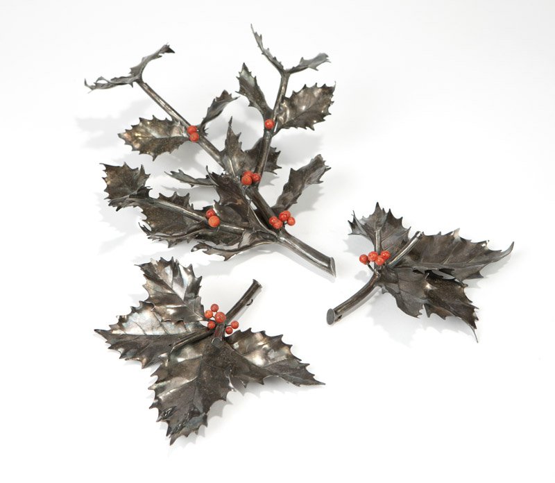 A set of Buccelatti sterling silver table ornaments: After 1968, Milan, with registration mark, further marked ''Buccellati'' and ''925'', naturalistically modeled as holly leaf sprays, with red-painted berries, 3 pcs, the larger 3.5'' H x 10.5'' W x 9.