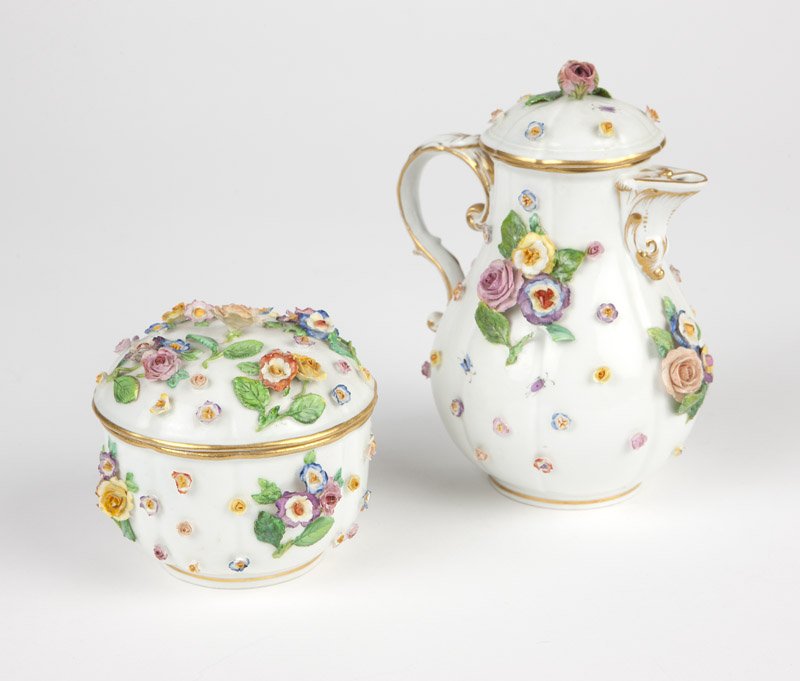 A Meissen coffee pot & sugar bowl: Mid 20th century, each with underglaze blue crossed swords mark, each decorated with polychrome-painted applied flowers on a white ground with gilt highlights, with rosebud finials, 2 pcs, the coffee