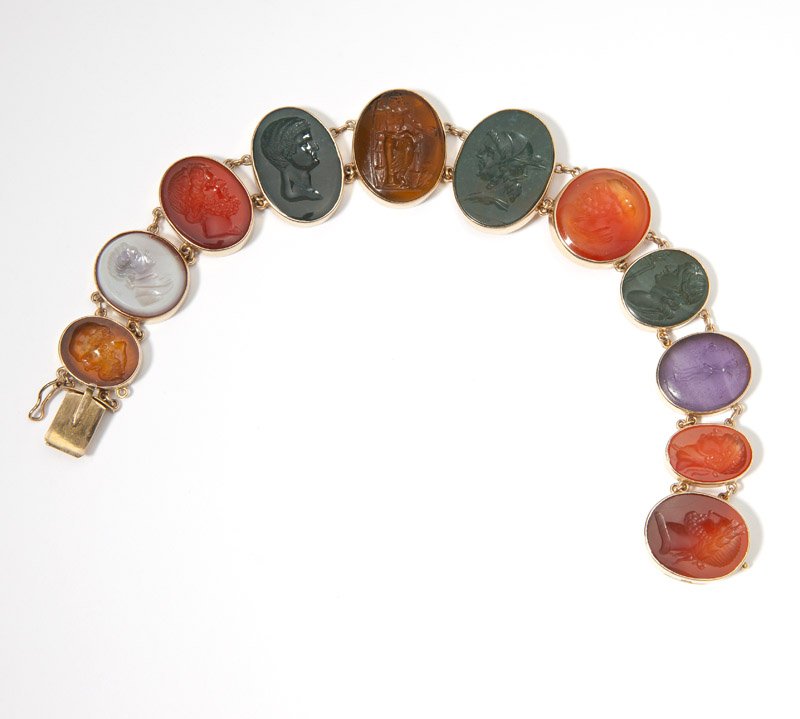 A stone, glass and gold intaglio bracelet: 14K gold, set with sectionals of carved carnelian, sardonyx, bloodstone and glass of mostly male portraits, 7 3/4'', 33.2 gms gross, est: $800/1200