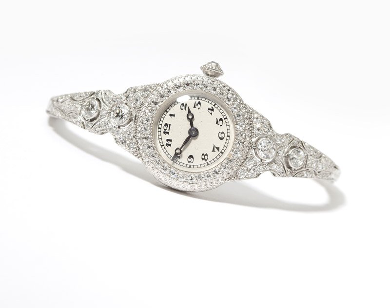 A Lady's Edwardian platinum wristwatch: Circa 1910, platinum, set with four full-cut diamonds and 84 single-cut diamonds totaling approximately 1.05 cts, graded G-H-I color and SI clarity, round dial unsigned, movement signed Merimont Watch