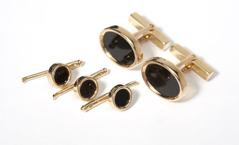 An onyx and gold dress set, Tiffany & Co: Signed Tiffany & Co. 18K, with oval onyx tablet inlay, including a pair of cufflinks with a set of three shirt studs, 15.7 gms gross, 5 pcs, with two fitted boxes, est: $500/700