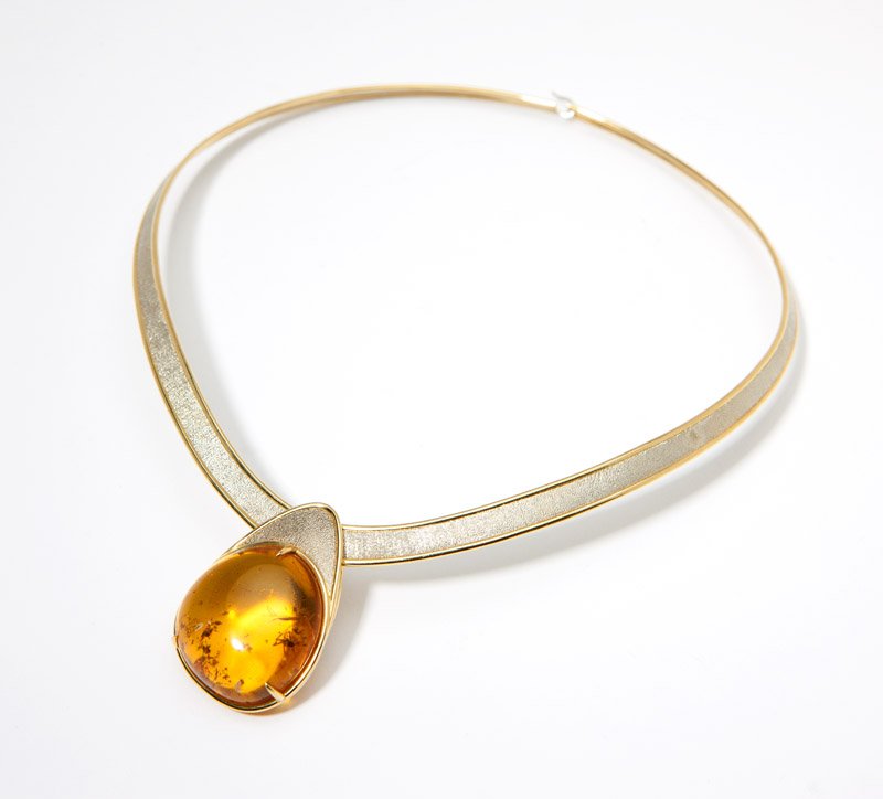 A bi-color gold collar and amber drop pendant: Stamped for Silverhorn, an 18K bi-color gold collar with textured center white gold, with an amber drop pendant, 16'', 46.9 gms gross, est: $600/800