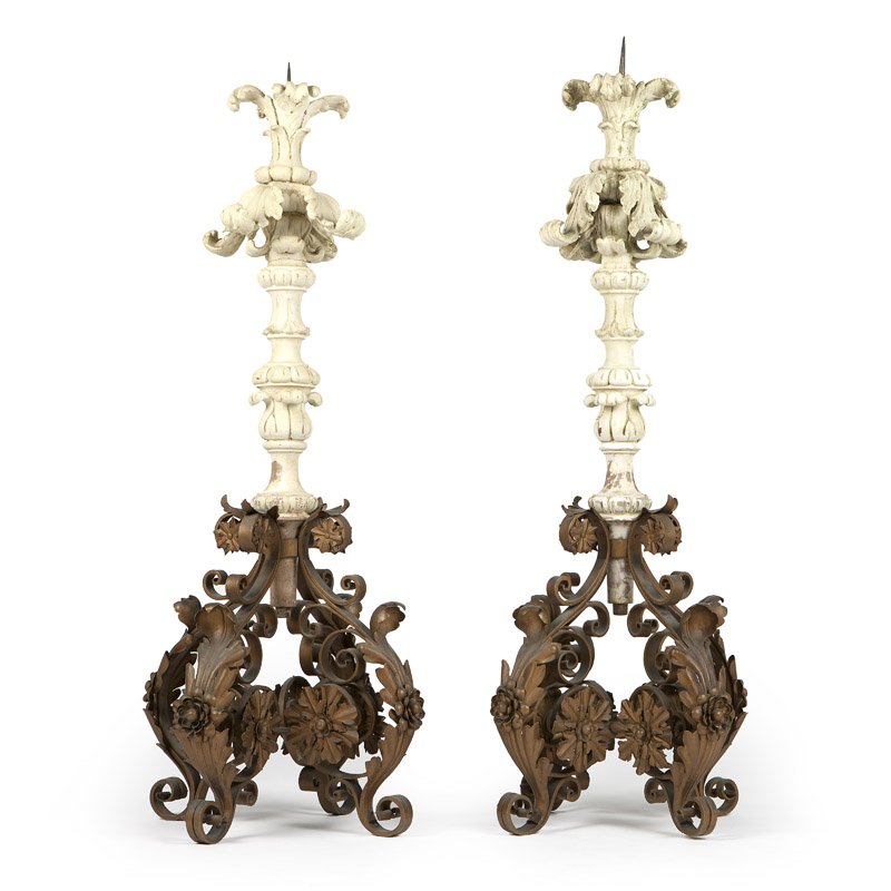 A pair of Continental carved wood and gesso pricket: 19th century, each with a spire pricket surmounting a carved and gesso wood acanthus-decorated stem, raised on a scrolling quatrefoil wrought iron base adorned with floral medallions, 2 pieces, the fi