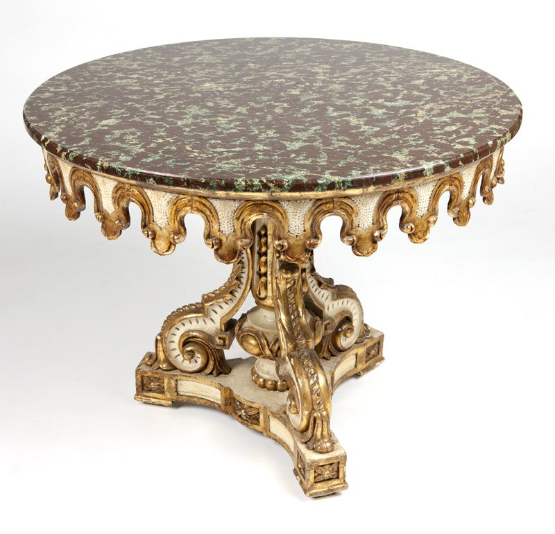 A Continental gilt & white-painted center table: Late 19th / early 20th century, in the Italian Baroque style, the circular variegated stone top over a foliate-carved apron on a scrolled tripartite pedestal base, 31'' H x 39.5'' Dia., est: $1500/250