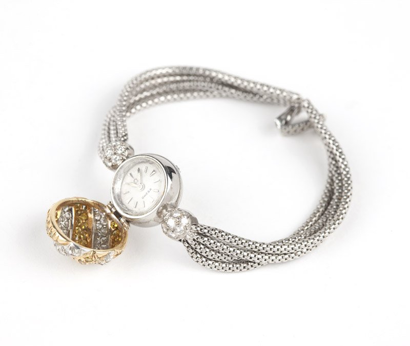 A lady's diamond covered dial wristwatch, Omega: A lady's Omega hidden dial wristwatch, the curved and retractable hinged circular cover set with circular-cut white and yellow diamonds totaling approximately 1.10 cts, opens to a round white dial wit