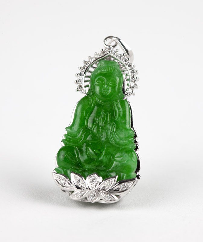 A jadeite and diamond pendant of Quan Yin: A 14K white gold frame pendant set with 25 full-cut diamond surround, centering a carved jadeite jade of Quan Yin, 2 1/8'' x 7/8'', est: $1200/1800