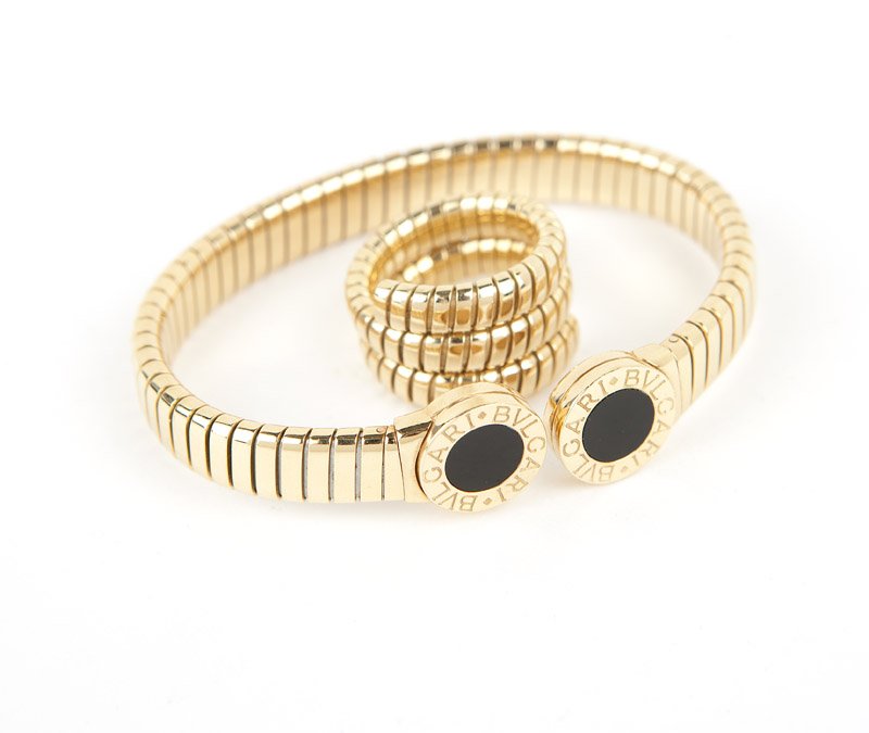 A gold and black onyx tubogas set, Bulgari: Stamped Bvglari, 750, Made In Italy, ''Bvglari-Bvglari'', 18K gold tubogas bracelet with onyx terminals together with a plain tubogas ring, 52.8 gms gross, ring adjustable, with box, est: $1500/2000