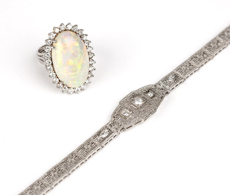 A group of white gold and gem jewelry: A 14K white gold ring centering an oval white opal with a diamond surround together totaling approximately 1.20 cts, graded H-I color, SI-I clarity, together with a 14K white gold filigree bracelet wi