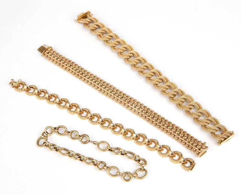 A collection of gold chain bracelets: A group of four 18K gold bracelets: one flat textured double curb, one alternating size hollow link, one fancy flat link and one textured link with sphere center trim, Italy, 80.9 gms, 4 pcs, est: $12