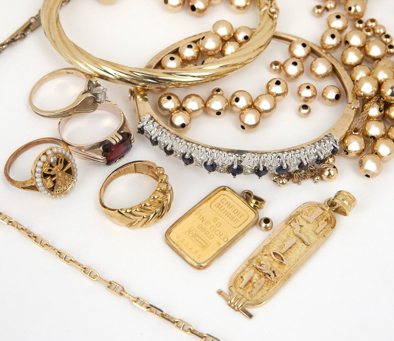 A group of various gold jewelry: Of 18K, 14K and 10K gold: one credit Suisse pendant, four rings, two bangles (one with gems), one cartouche, two chains and a group of 14K gold beads, 68.3 gms gross, est: $1000/1500