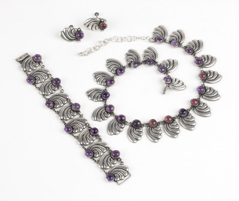 An amethyst suite, R.R.: Stamped R.R., Sterling , Taxco, a conch motif sectional necklace, bracelet and pair of matching screw-back earrings topped with various tones of amethyst round cabochons, hook and eye closure, necklac