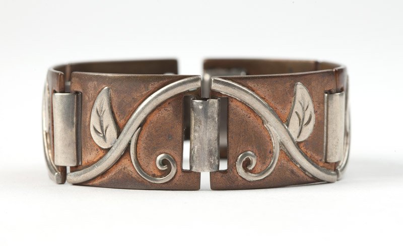 A copper and silver bracelet, Hector Aguilar: Stamped for Hector Aguilar, 940, Taxco, eagle mark 9, a copper with silver vine overlay sectional bracelet, box clasp, 6 3/4'', 63 gms gross, est: $100/200 Provenance: Property from a Southern Califor