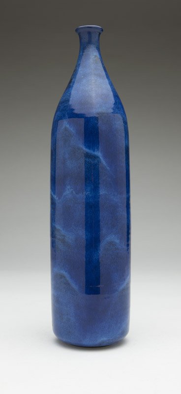 Gertrud & Otto Natzler (1908-1971) & (1908-2007 Los: Mid-20th century, signed in black ''Natzler'' and with paper label ''#12/RH'', a ceramic bottle, the cylindrical body rising to a tapering neck surmounted by a slightly flaring mouth, in an all-over c