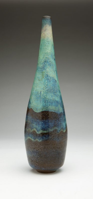 Gertrud & Otto Natzler (1908-1971) & (1908-2007 Los: Mid-20th century, signed in black ''Natzler'' and with paper label ''M206'', a ceramic bottle, the cylindrical tapering body in an all-over mottled brown, blue-green and blue glaze, 17'' H x 4.5'' Dia