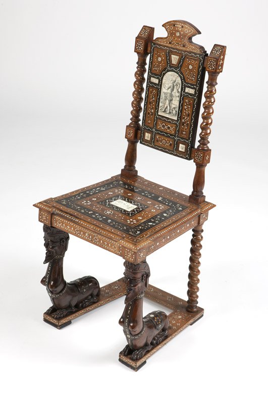 An Italian Renaissance-style hall chair: Late 18th/early 19th century, of walnut carved and all-over inlaid with bone, mother-of-pearl, brass and various fruitwoods, the crested rectangular back centered by an engraved bone panel depicting a