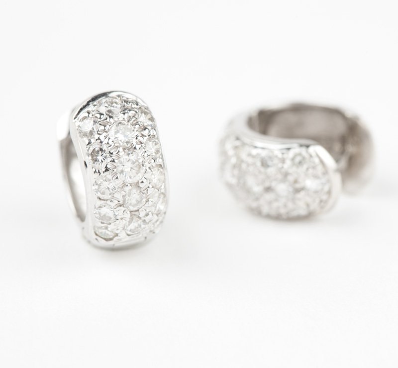 A pair of diamond and white gold huggie earrings: 18K white gold set with full-cut diamond accents totaling approximately 0.55 ct., 4.8 gms gross, est: $400/600