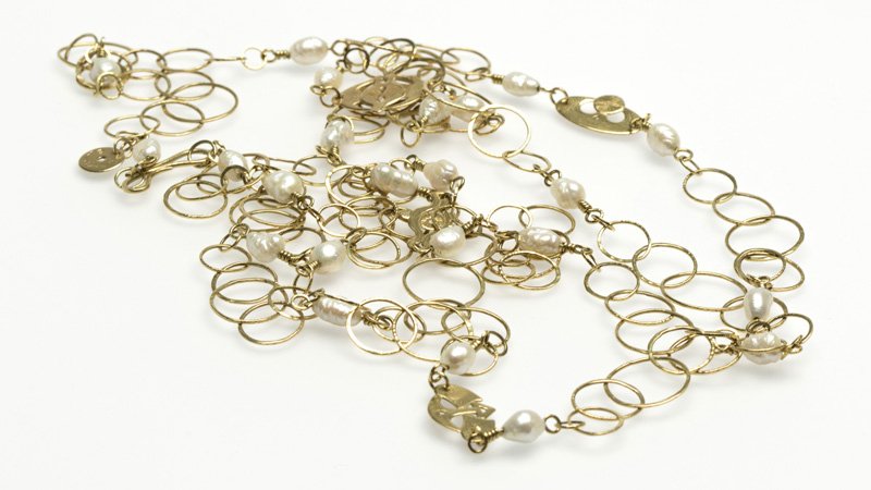 A cultured pearl and gold necklace, De La Cuerva: Signed De La Cuerva, 18K yellow gold textured circular link long necklace separated with freshwater cultured pearls and gold sectionals, length 74'', 50.6 gms gross, est: $900/1100 Provenance: Estate