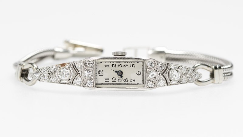 A diamond and platinum ladies cocktail wristwatch: Platinum case set with full and single-cut diamonds totaling approximately 0.80 ct., movement signed Ernest Borel, Swiss, 17 jewel unadjusted, on white gold bracelet extender, 22.7 gms gross, est: $10